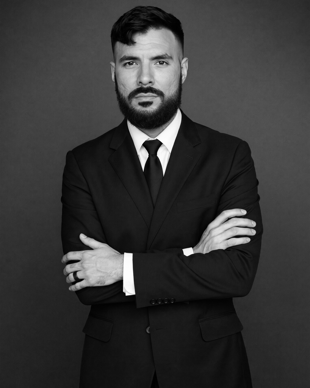 Gerardo Mata, arms crossed, fine-art black and white studio portrait