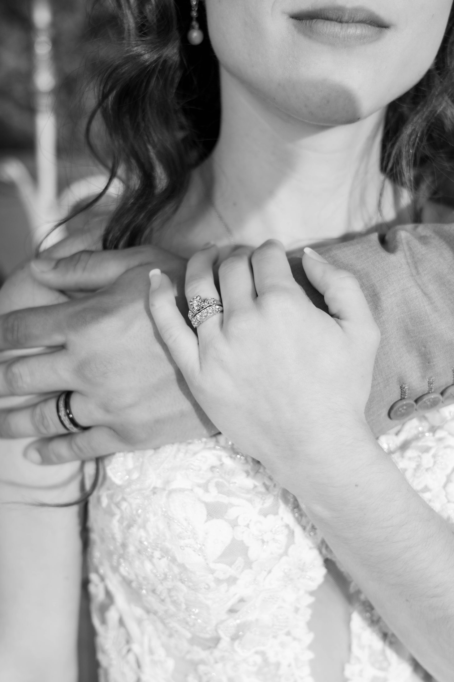 A couple share their first kiss beneath a cross in warm black and white