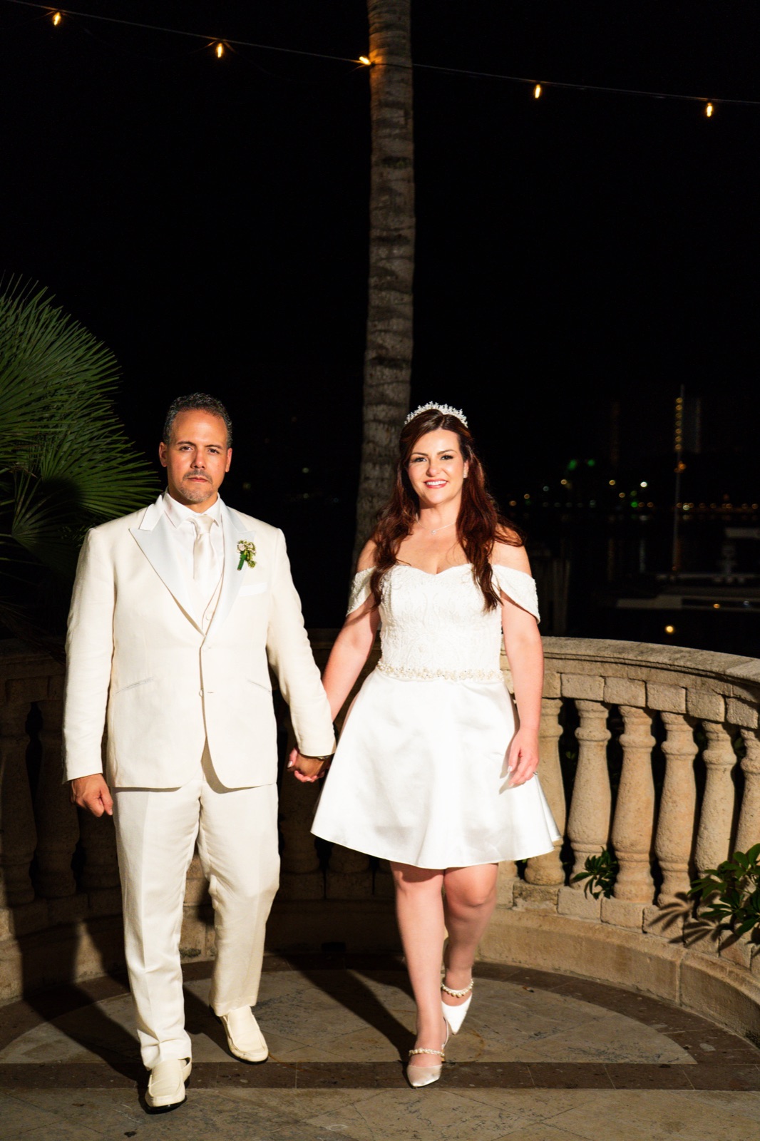 Newlyweds walking hand in hand at night