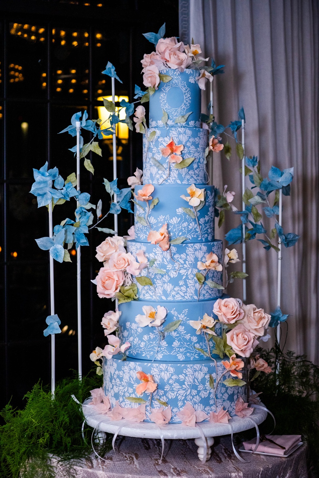 The grand tiered wedding cake with blue and blush florals