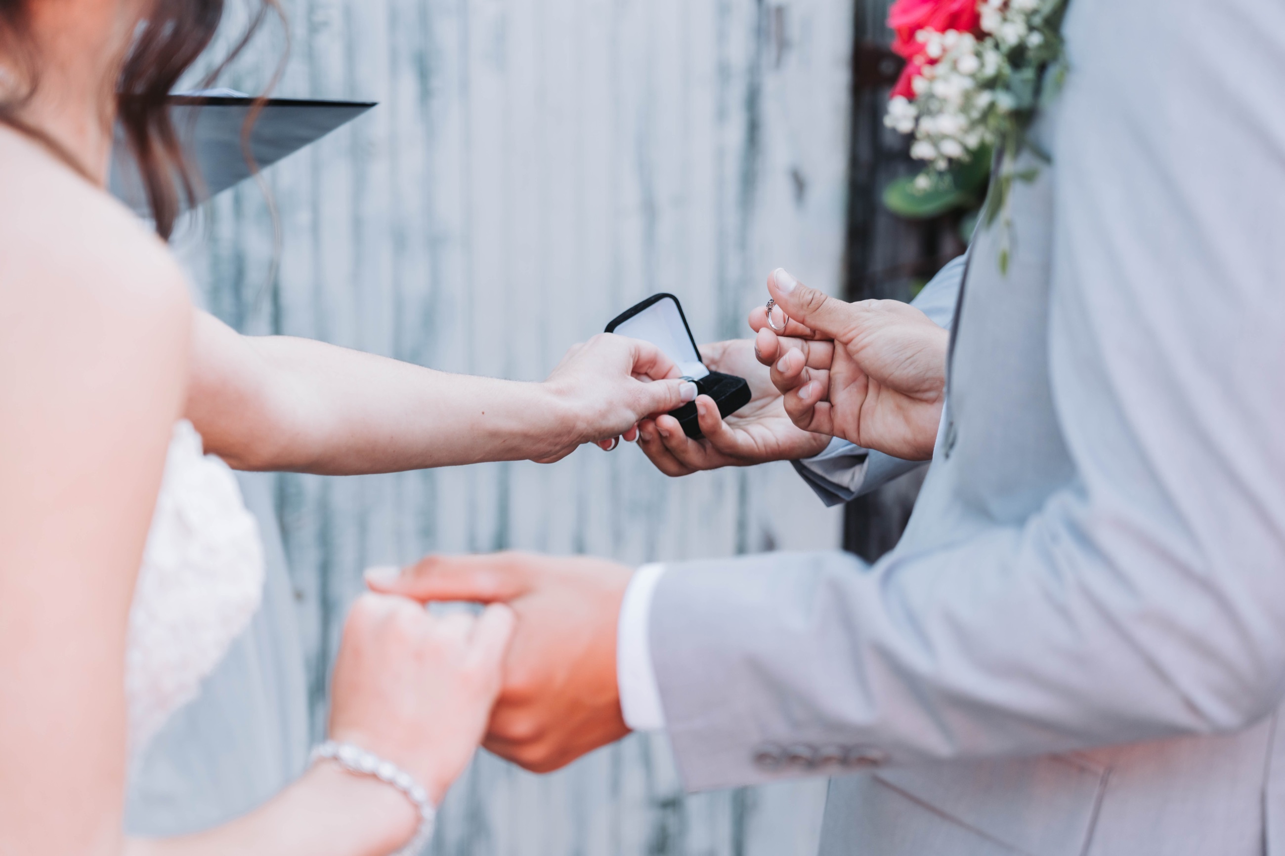 A bride and groom exchange rings during their ceremony, the ring lifted from its box, at a rustic Florida wedding photographed by GM Productions