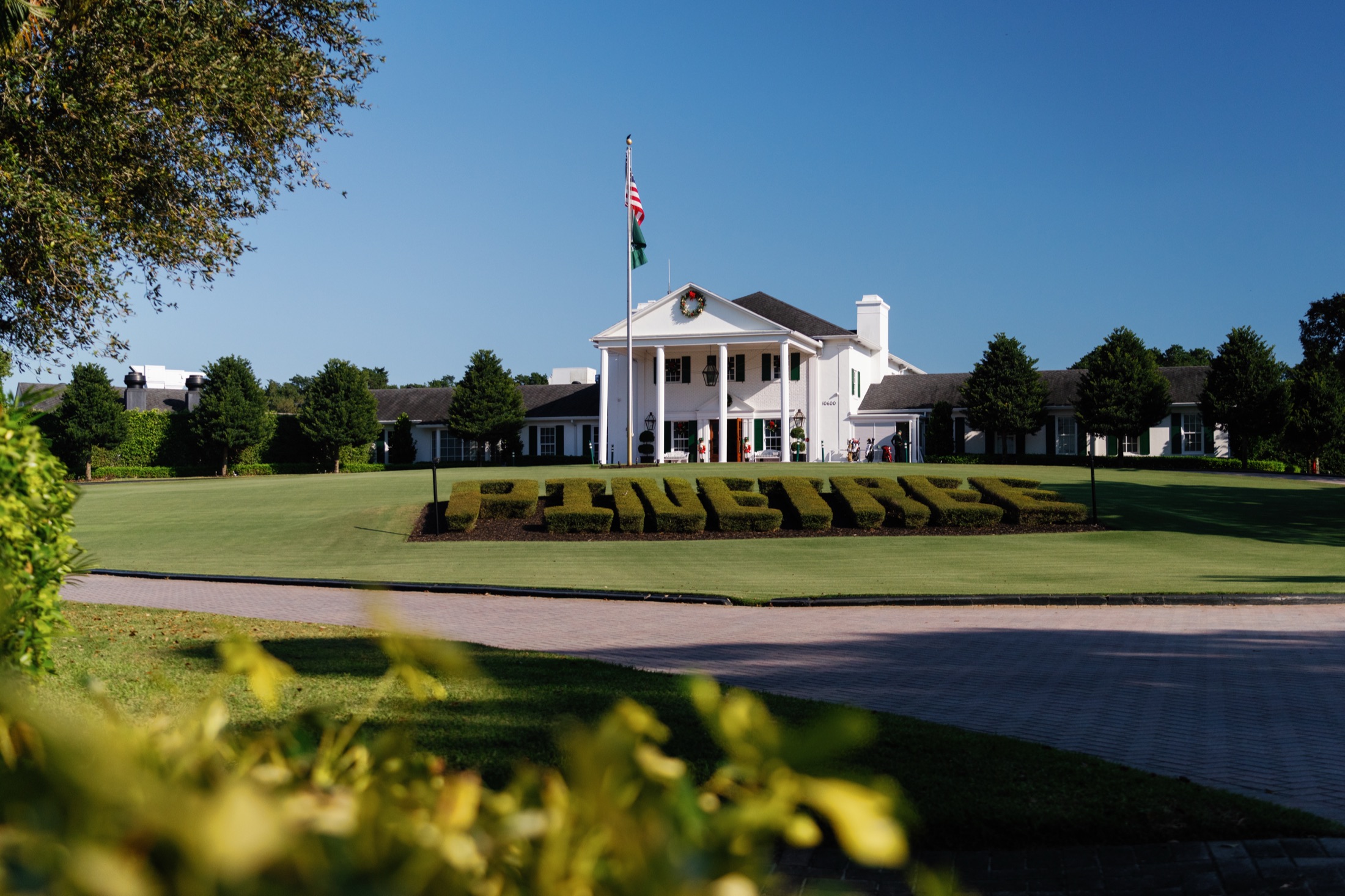 The grand white colonial clubhouse at Pine Tree Golf Club, a luxury South Florida wedding venue photographed by GM Productions